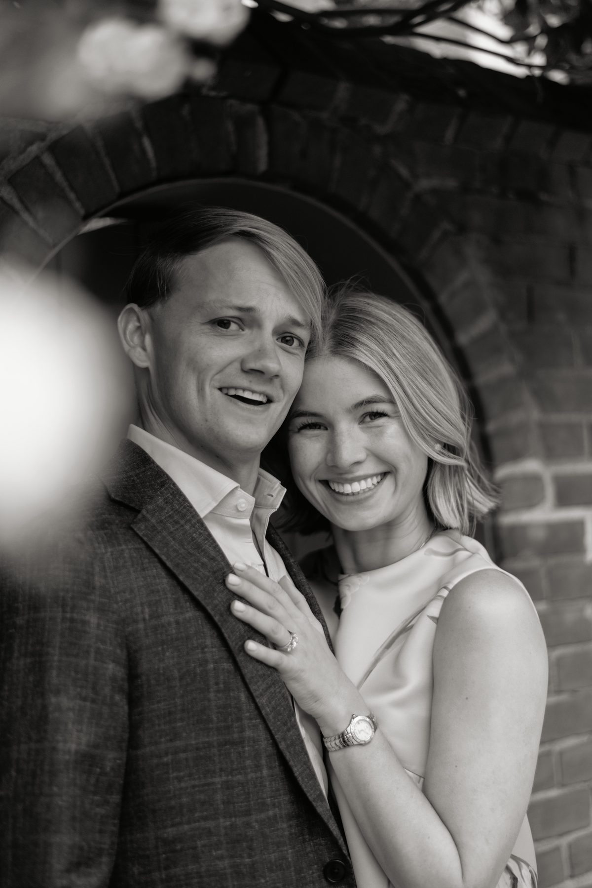Nolan and Nikole smiling together in front of a brick archway